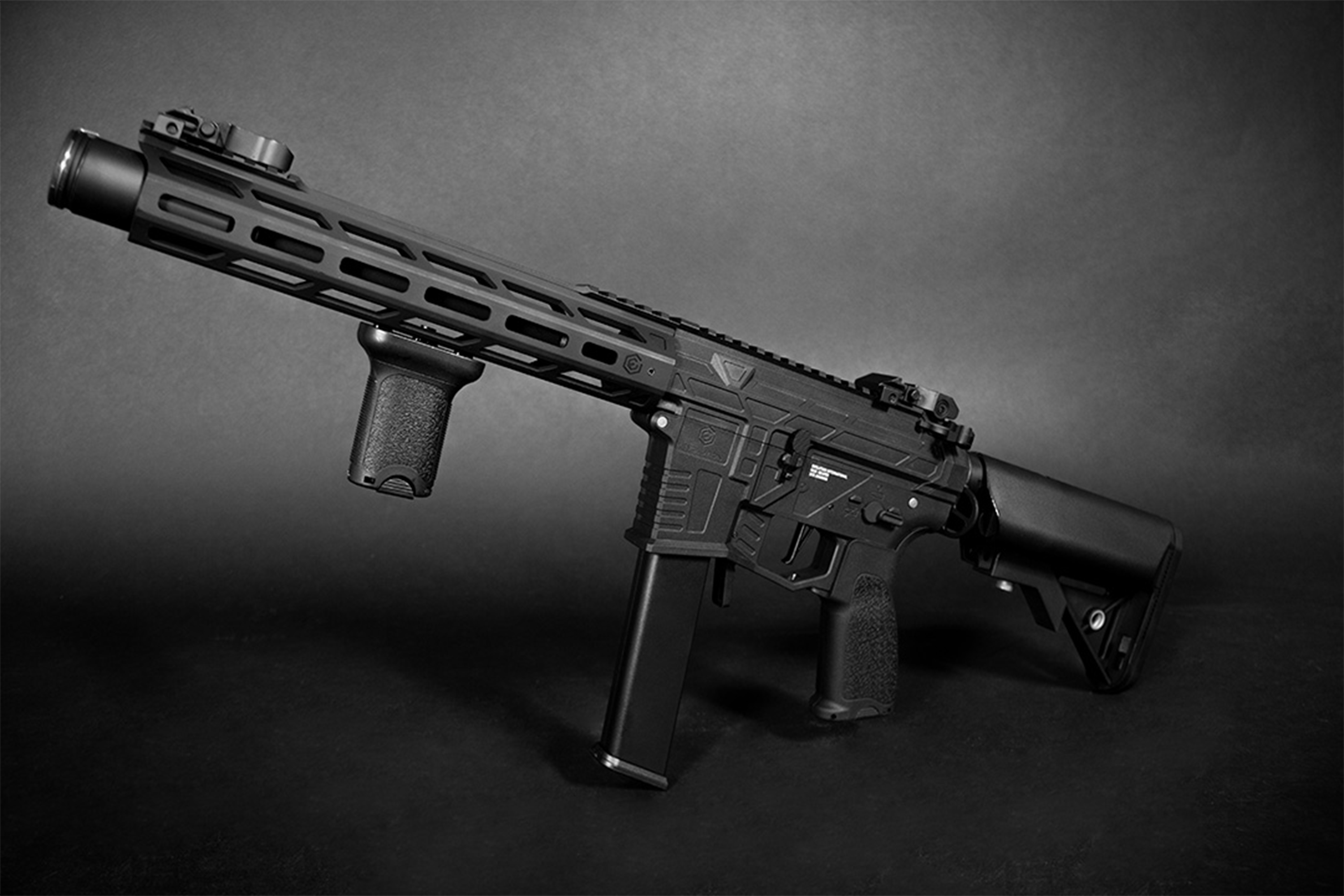 Schwarzes taktisches Airsoft-Karabinergewehr mit M-LOK-Handschutz, vertikalem Vordergriff und verstellbarem Schaft auf dunklem Hintergrund.