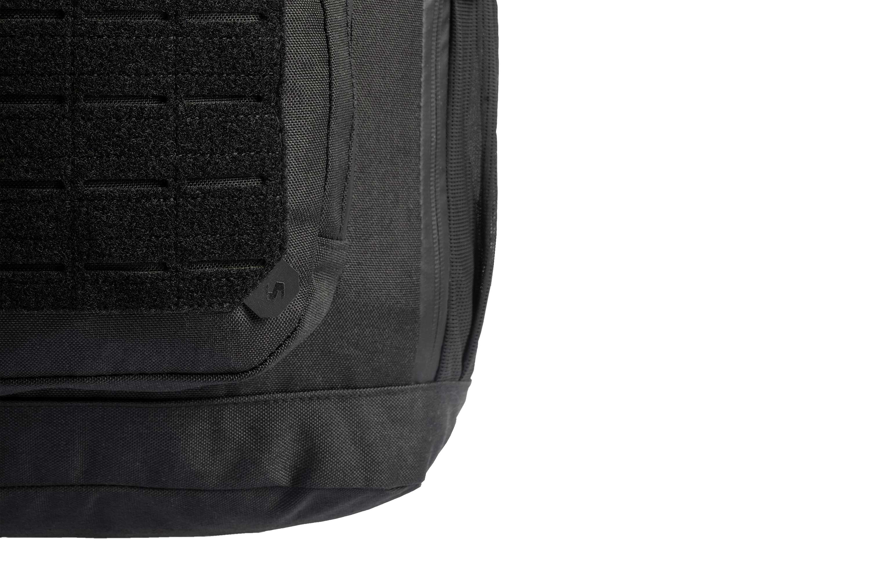 Nahaufnahme eines schwarzen taktischen Rucksacks aus strapazierfähigem Stoff, MOLLE-Gurtband und einem kleinen Markenlogo-Aufnäher.