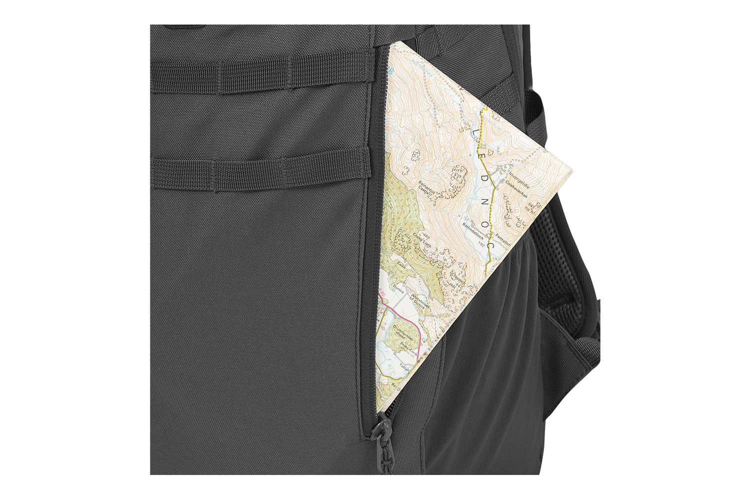 Nahaufnahme eines schwarzen taktischen Rucksacks mit einer seitlichen Reißverschlusstasche, in der sich eine gefaltete topografische Papierkarte befindet.