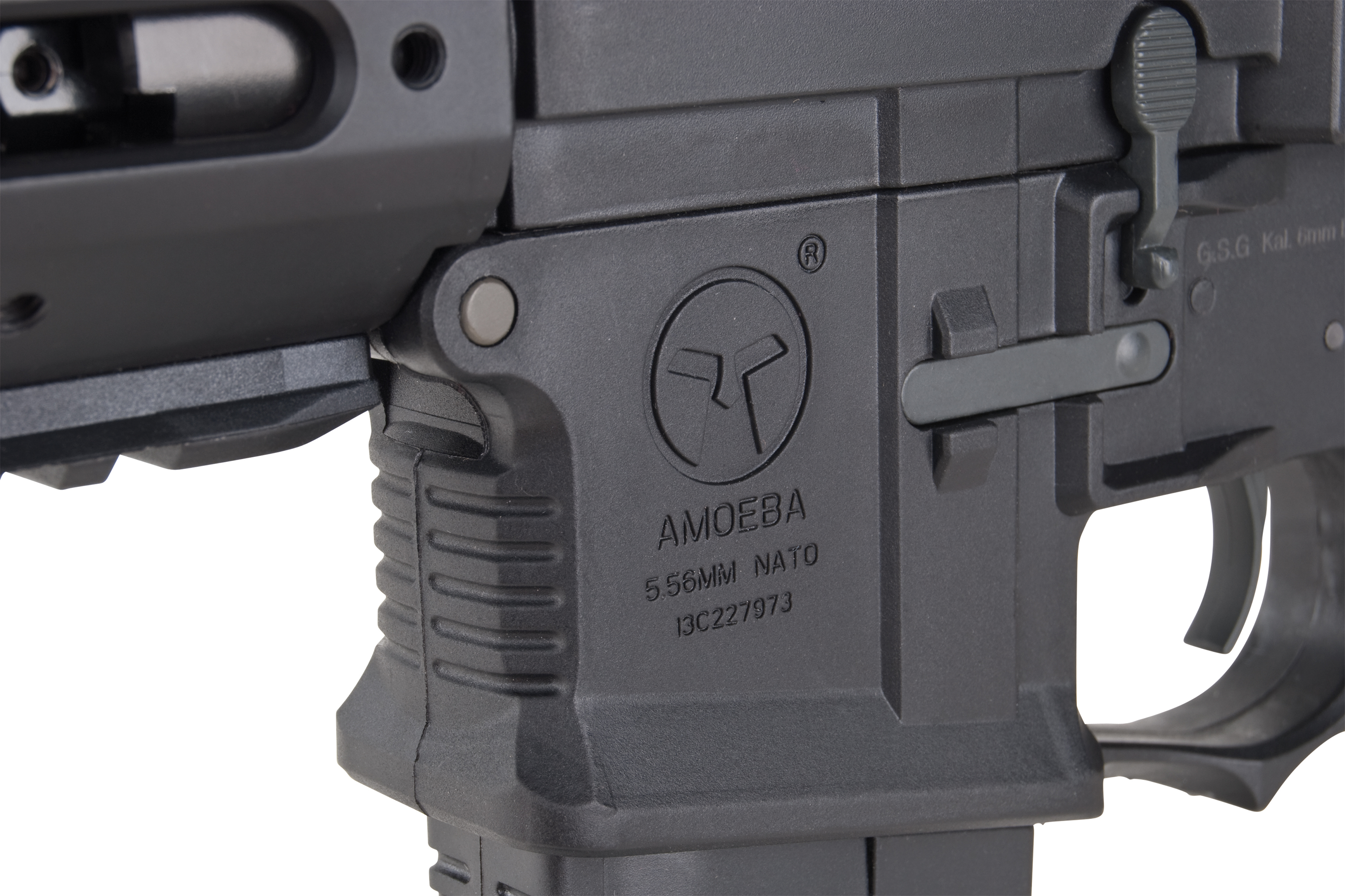 Nahaufnahme des schwarzen Polymerempfängers eines Amoeba-Airsoftgewehrs mit Markenlogo und 5,56-mm-NATO-Markierungen.
