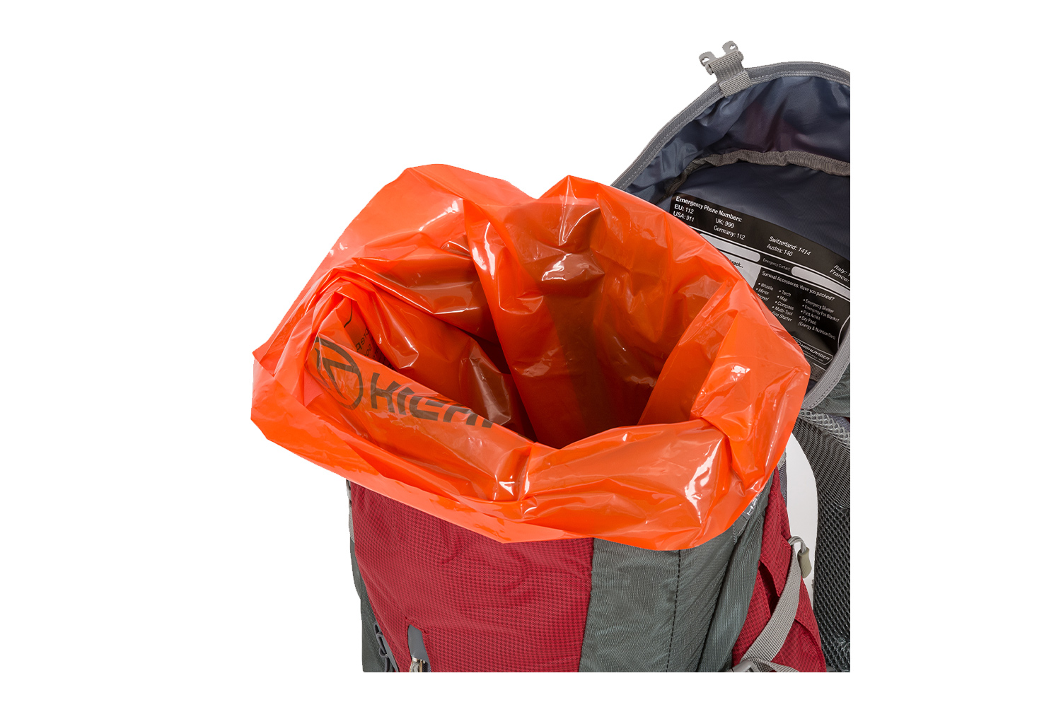 Offener rot-grauer Wanderrucksack mit leuchtend orangefarbenem, wasserdichtem Innenfutter und aufgedruckten Notfallinformationen.
