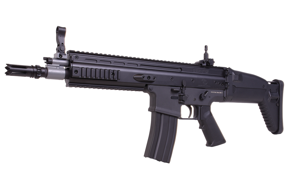 Schwarzes Airsoft-Gewehr GSG FN SCAR-L mit taktischem Schienensystem, verstellbarem Schaft und Mündungsfeuerdämpfer auf weißem Hintergrund.