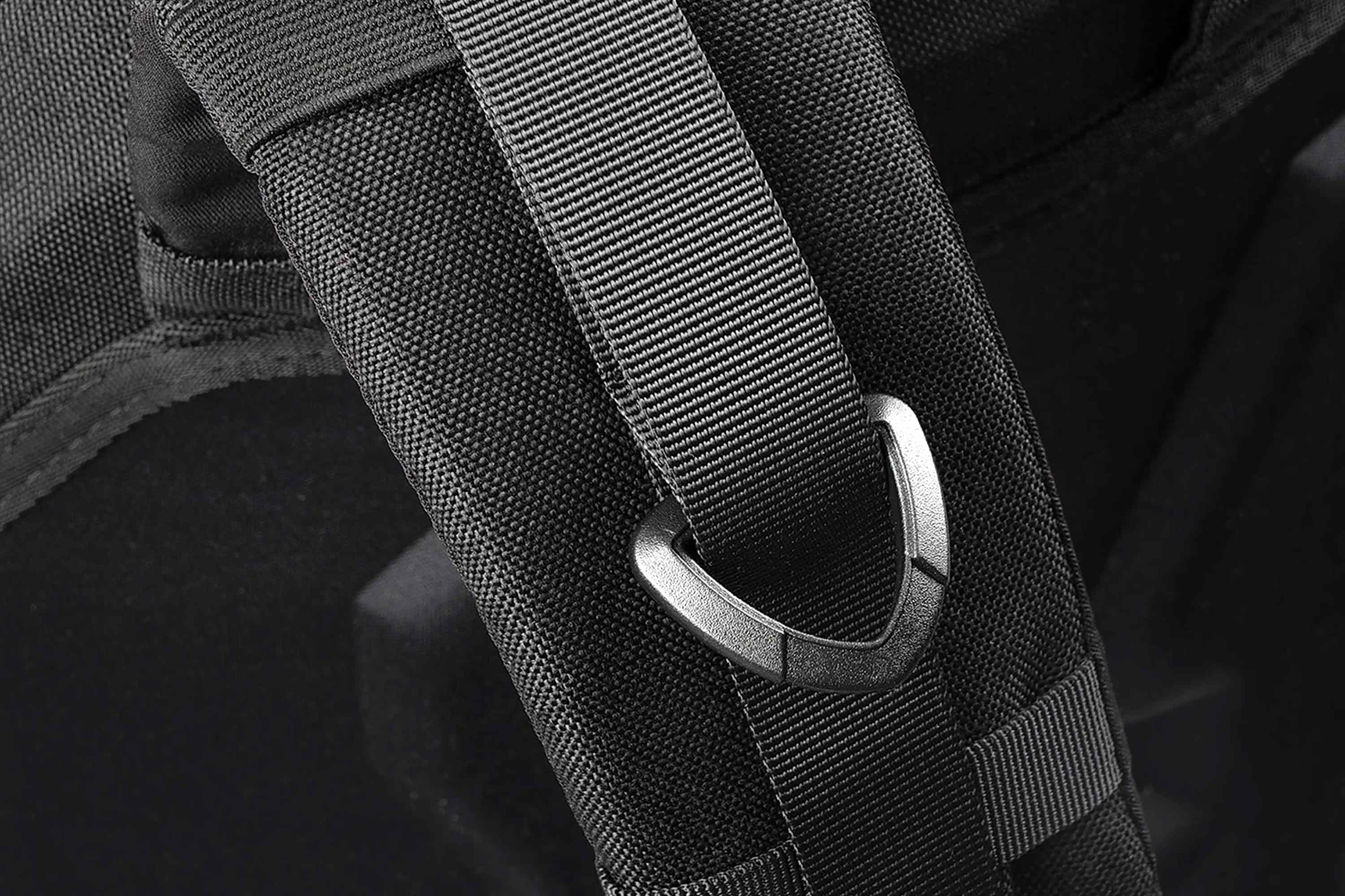 Nahaufnahme eines robusten schwarzen Schultergurts für einen taktischen Rucksack mit einem stabilen D-Ring-Befestigungspunkt aus Metall.