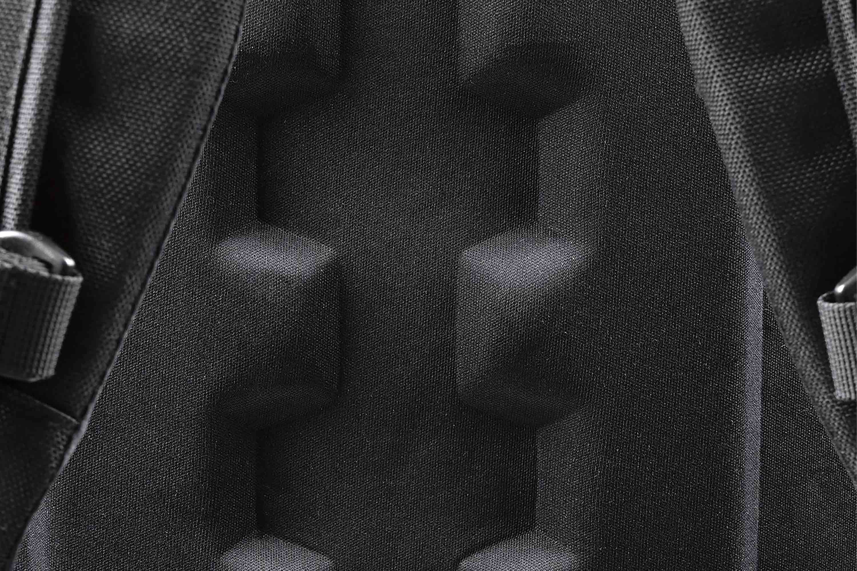 Nahaufnahme einer schwarzen Rückwand eines taktischen Rucksacks mit ergonomischen, gepolsterten Schaumstoffkissen für Komfort und Belüftung.