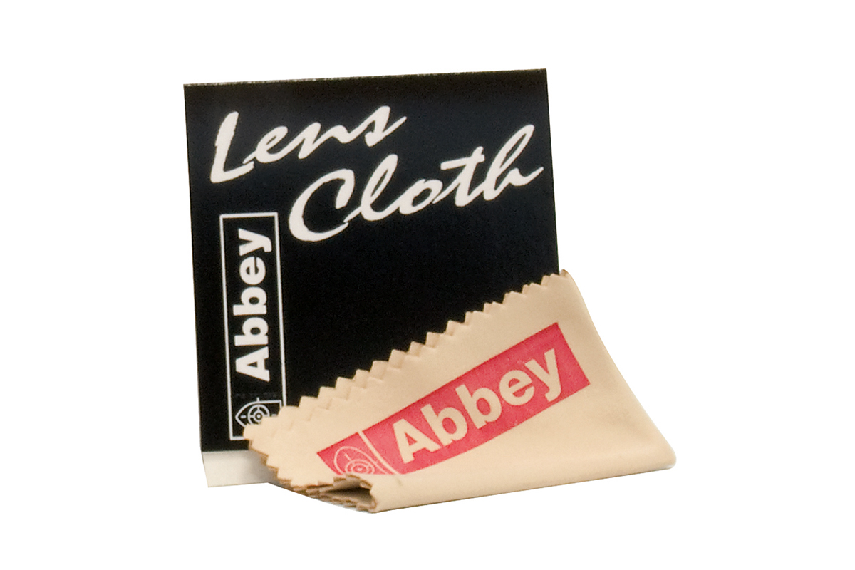 Abbey-Linsentuch zur Optikreinigung, bestehend aus einem beigen Mikrofasertuch mit rotem Logo und schwarzer Verpackungshülle.