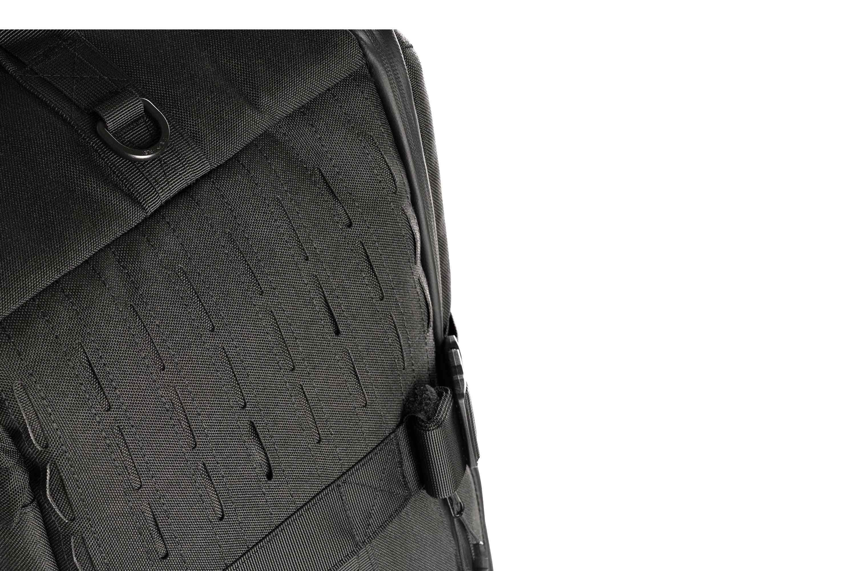 Nahaufnahme eines schwarzen taktischen Rucksacks mit lasergeschnittenem MOLLE-Gurtband, strapazierfähigem Nylongewebe und einem stabilen D-Ring.