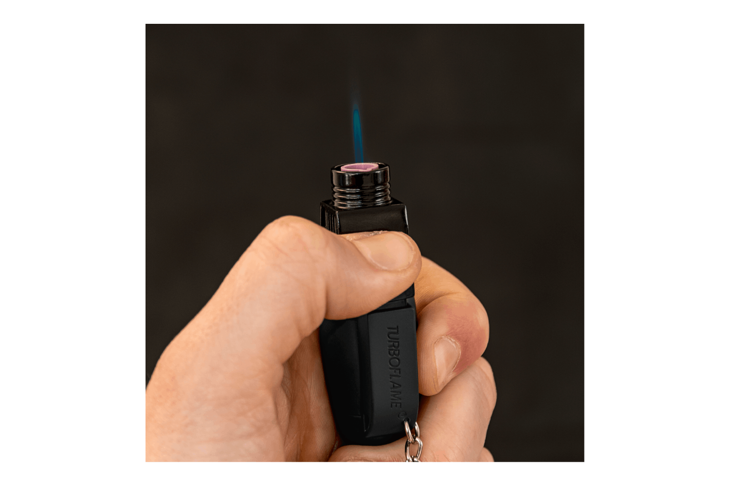 Hand hält ein Turbo Flame-Feuerzeug mit blauer Flamme, das sein elegantes Design und seine Funktionalität zur Schau stellt.