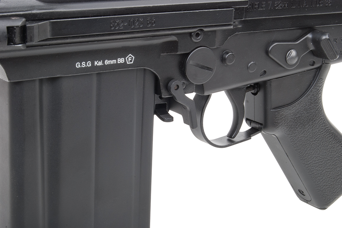 Nahaufnahme eines schwarzen GSG-Airsoft-Gewehrgehäuses mit 6-mm-BB-Kalibermarkierungen, Abzugsbügel und Magazingehäuse.