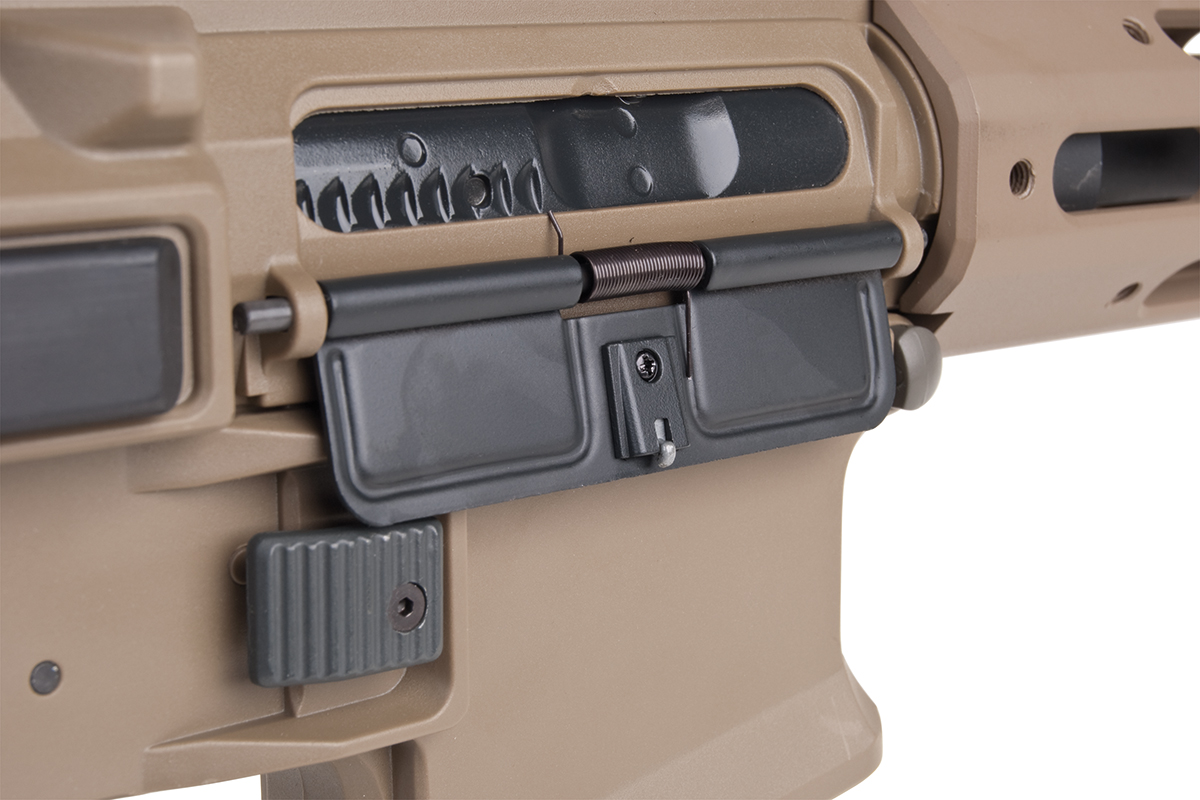 Nahaufnahme eines hellbraunen Gewehrgehäuses im AR-15-Stil mit schwarzer Staubschutzhülle, Verschlussträger und Magazinauslöseknopf.