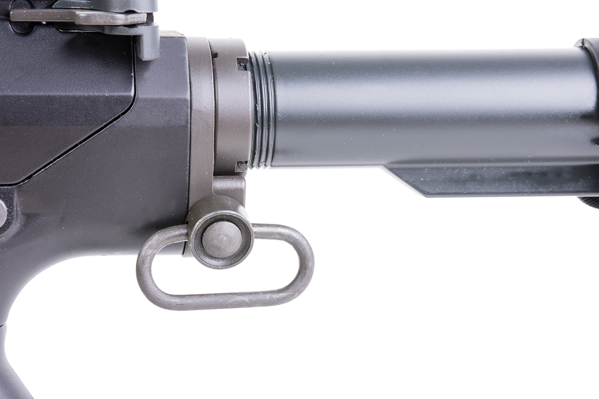 Schwarze, drehbare Riemenhalterung aus Metall, befestigt an einem Luftgewehr-Pufferrohr für den Aufbau taktischer Ausrüstung und Schusswaffenzubehör.