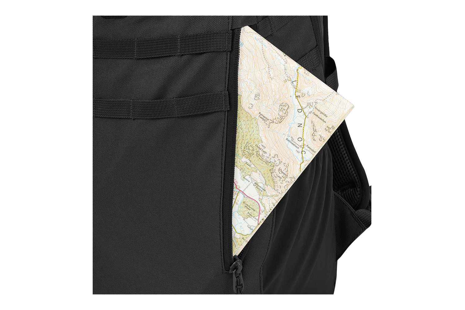 Nahaufnahme eines schwarzen taktischen Rucksacks mit einer Seitentasche mit Reißverschluss, in der sich eine gefaltete topografische Papierkarte befindet.