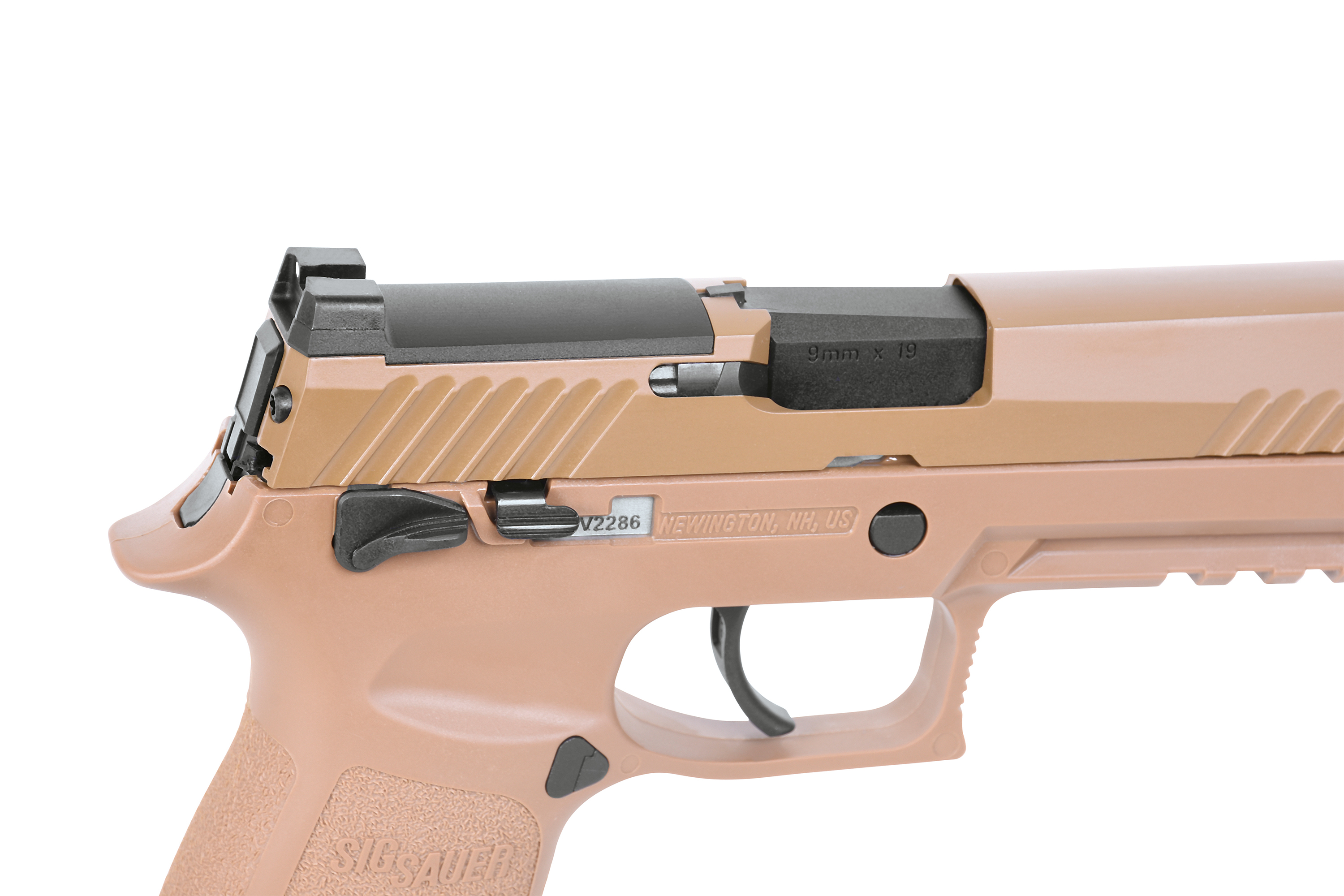 Nahaufnahme des Rahmens und Verschlusses einer hellbraunen Sig Sauer-Pistole mit Auswurföffnung, manueller Sicherung und strukturiertem Griffbereich.