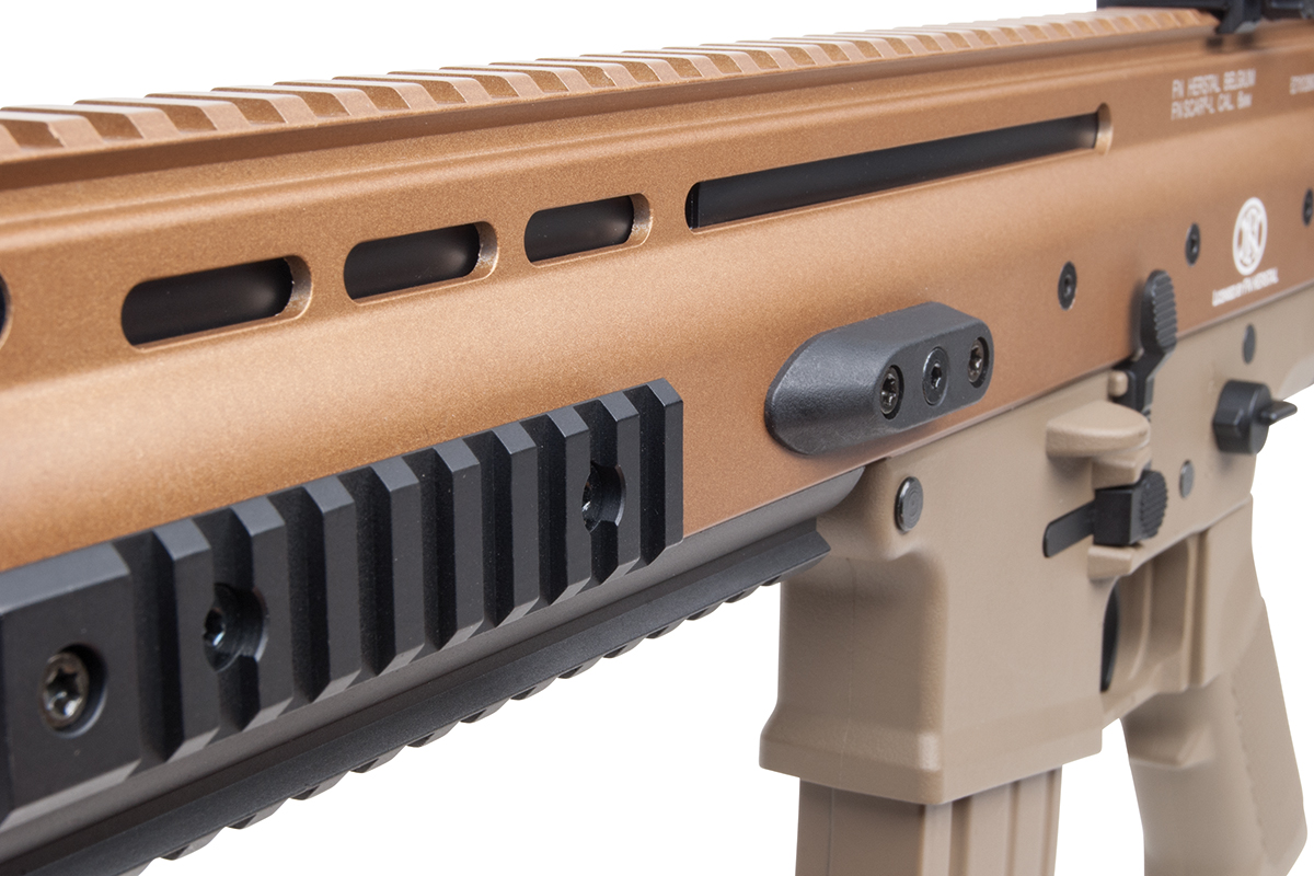 Nahaufnahme eines hellbraunen FN SCAR-L Airsoft-Gewehrs mit Metallgehäuse, oberer Picatinny-Schiene und schwarzer Zubehörhalterung.