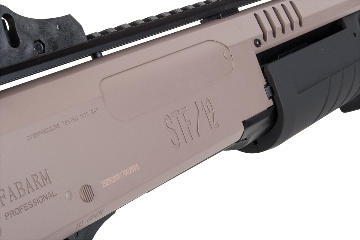 Nahaufnahme eines hellbraunen Fabarm STF/12-Schrotflintengehäuses mit schwarzer Schiene und Vorderschaft, mit Branding und technischen Markierungen.