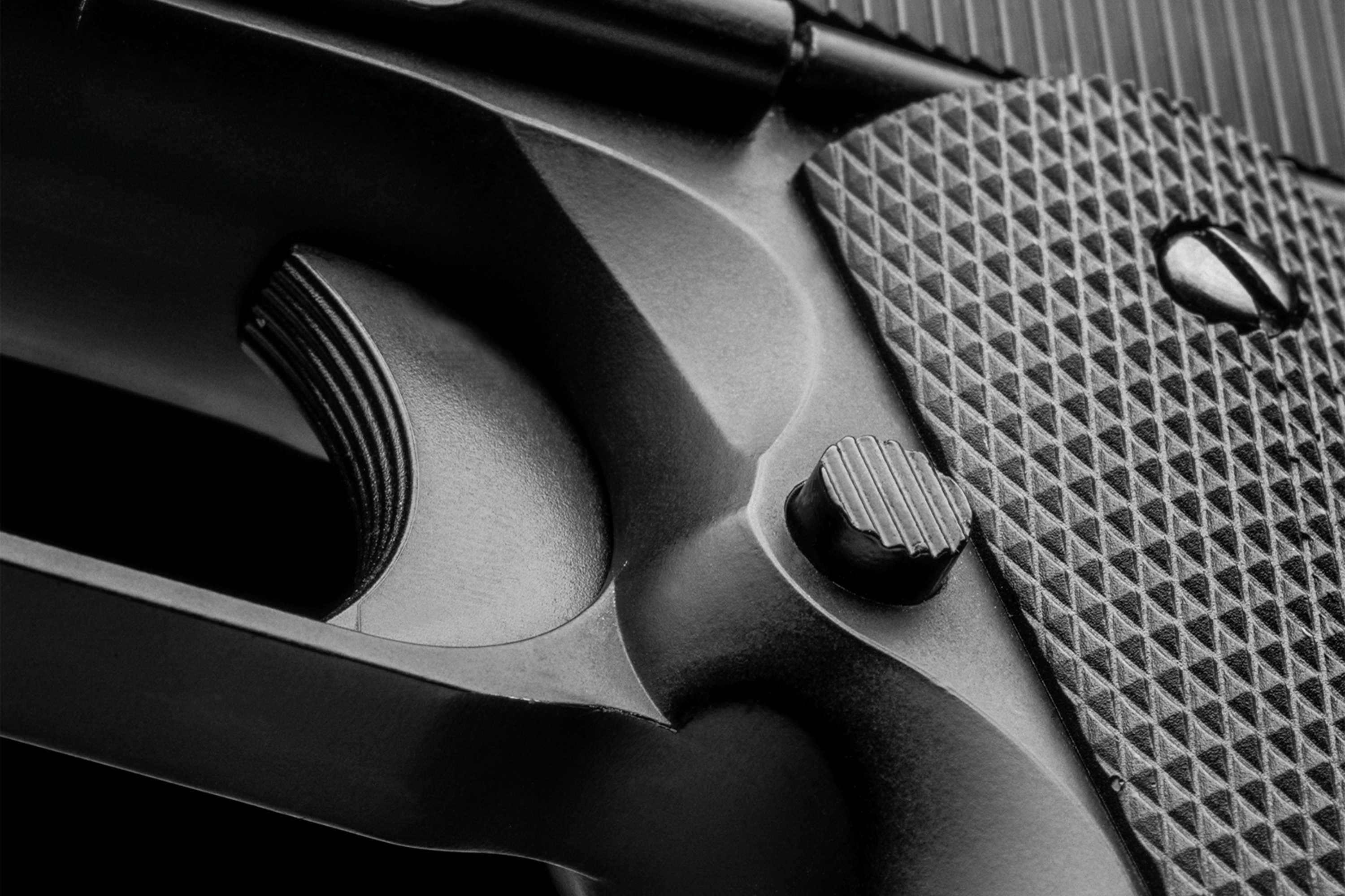 Nahaufnahme eines schwarzen Luftpistolengriffs mit strukturierter Oberfläche und Details des Abzugsmechanismus.