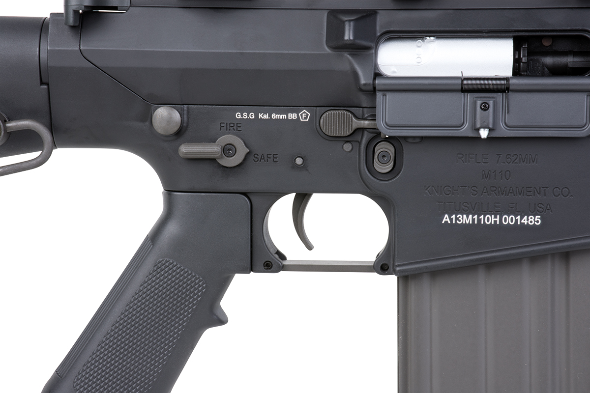Nahaufnahme des schwarzen Airsoft-Gewehrgehäuses GSG M110 mit Feuerwahlschalter, Abzug und Knight's Armament-Markierungen.