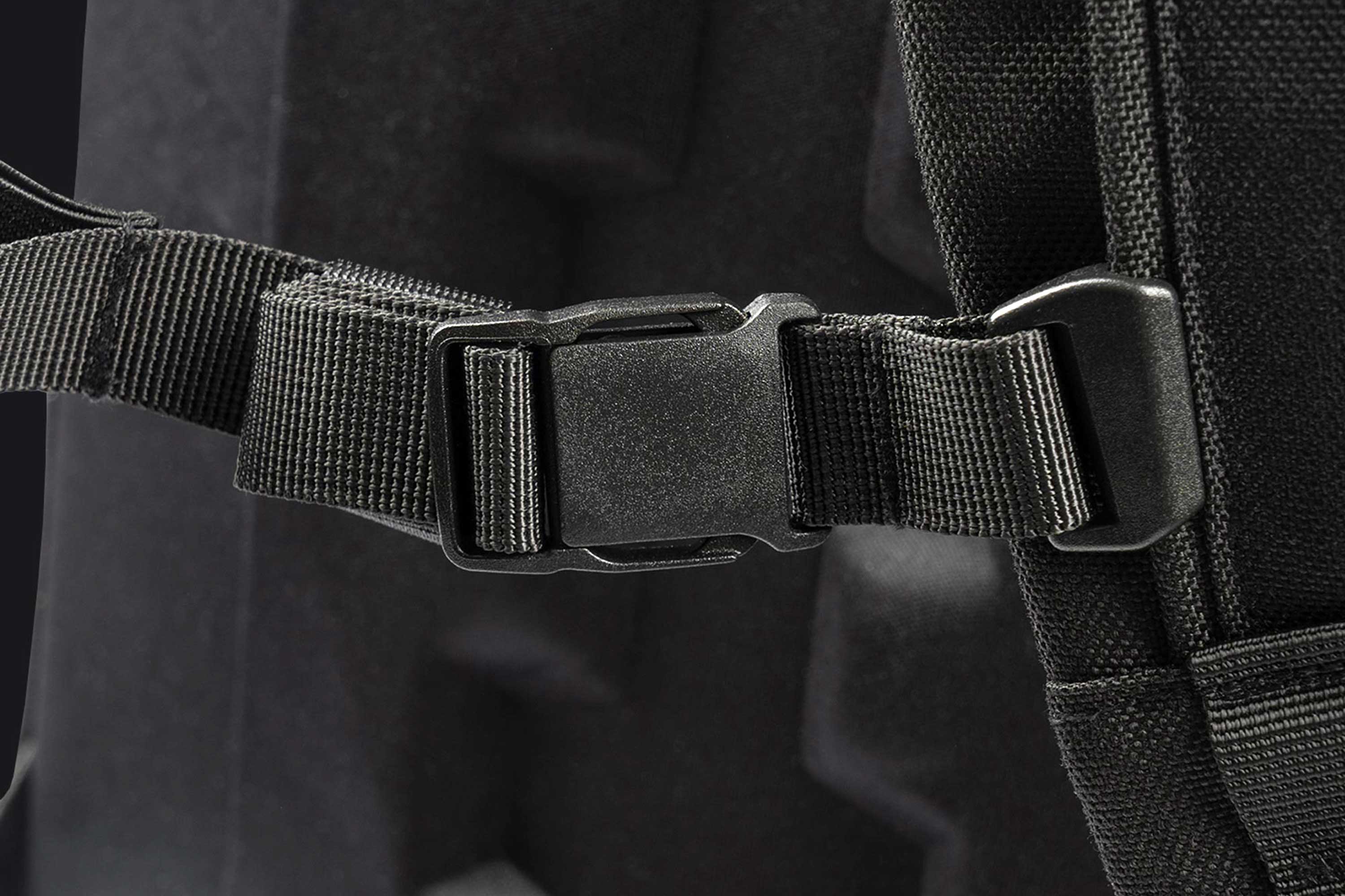 Nahaufnahme einer schwarzen seitlichen Kunststoffschnalle an einem strapazierfähigen Nylonband, Teil einer taktischen Ausrüstungstasche oder eines Rucksacks.